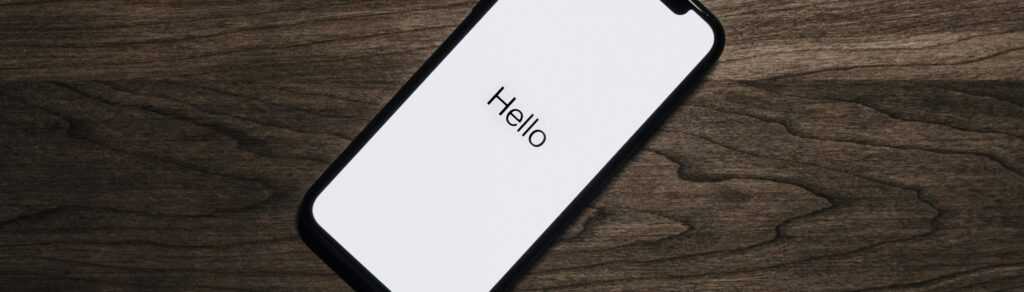 A smartphone displaying 'Hello' on a wooden surface, showcasing modern technology.